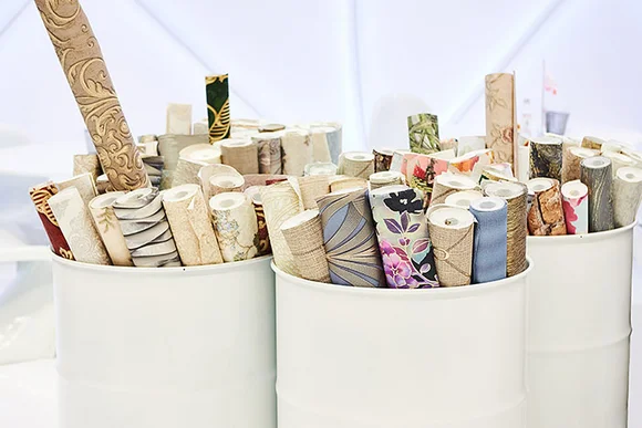 Verschiedene Tapetenrollen in Behältern